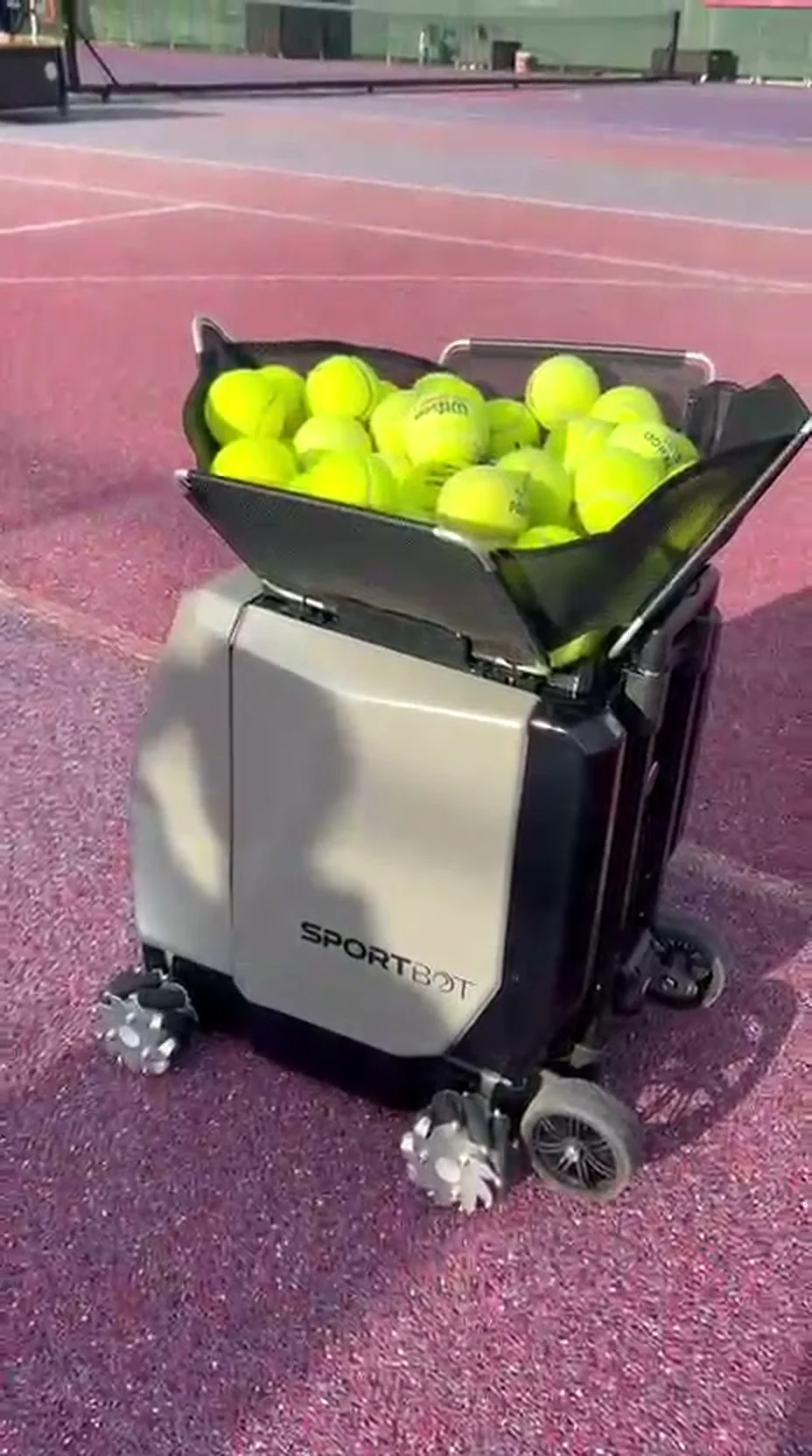 Sportbot machine filled with tennis balls on the BEYOND Berlin outdoor court