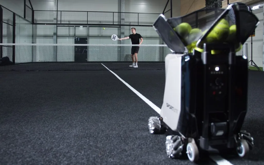 Padel player training with Sportbot on an indoor padel court