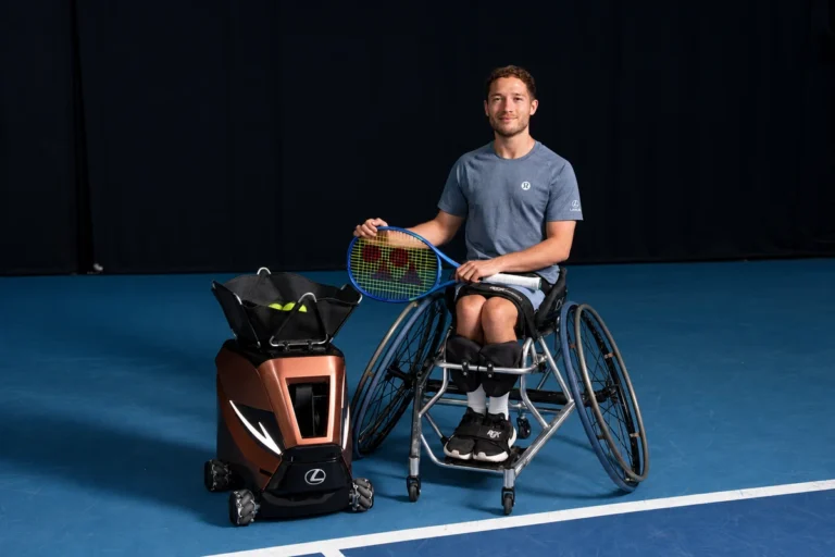 Alfie Hewett beside the copper Sportbot on a blue tennis court
